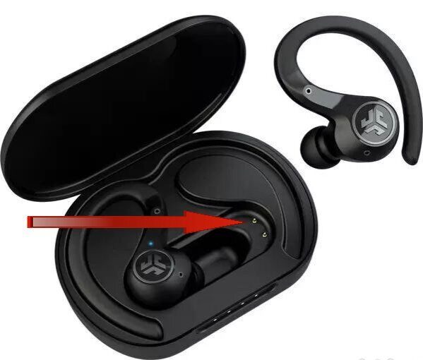 A red arrow pointing towards the charging contacts of a JLab earbuds