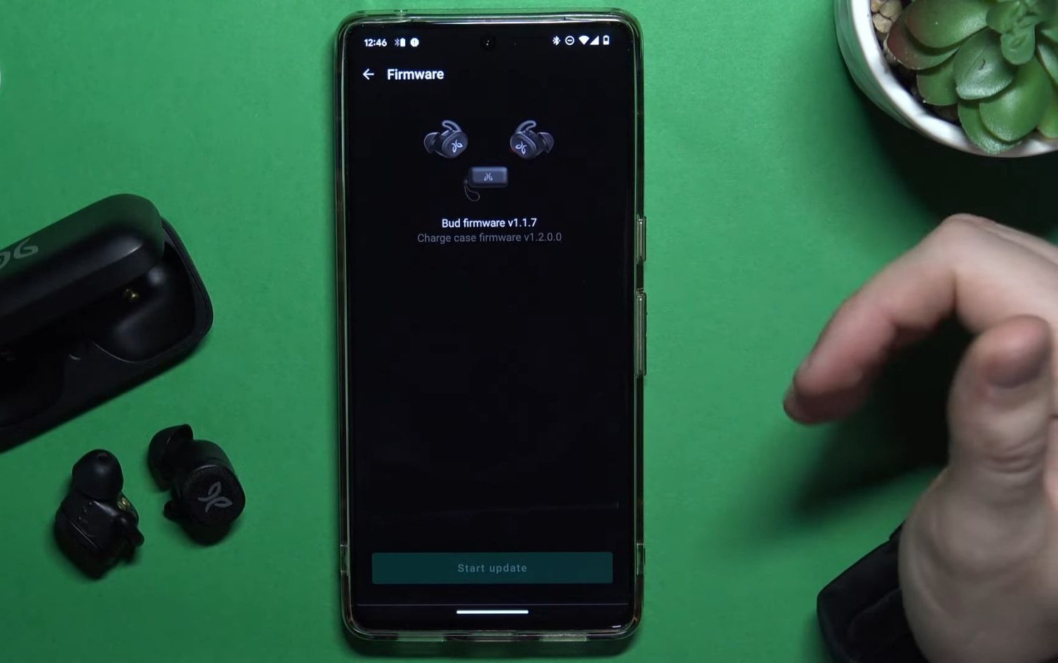 Jaybird Vista earbuds beside a smartphone with the update interface in the Vista app