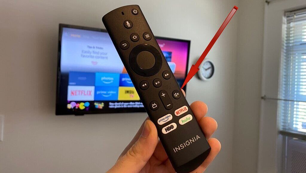 A red arrow pointing towards mute button on a remote